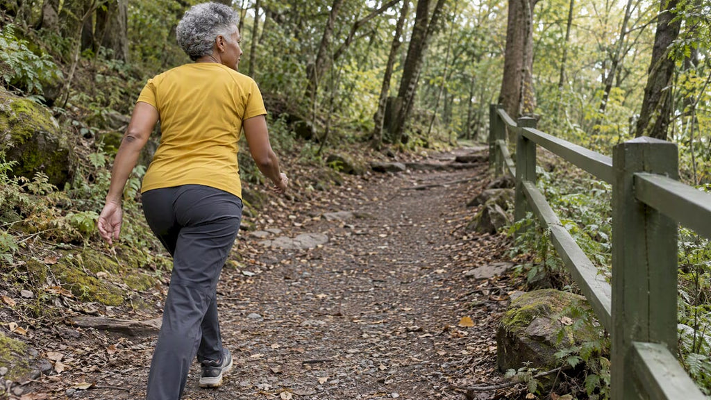 Older woman briskly walking uphill on a park path