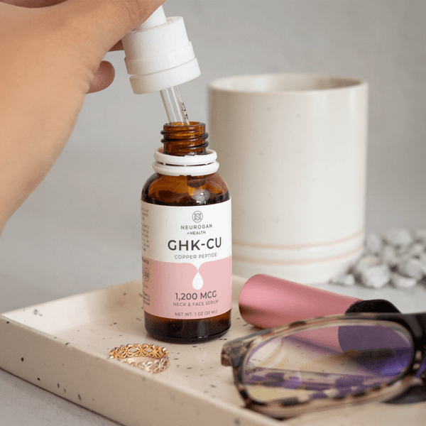 Neurogan Health GHK-Cu Copper Peptide Neck and Face Serum bottle with applicator in a lifestyle setting, showcasing skincare for face and neck.